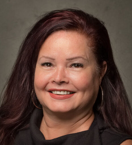 professional headshot of Tammy Carlin, board director for TAP Network. Long dark hair, smiling, wearing a black top.