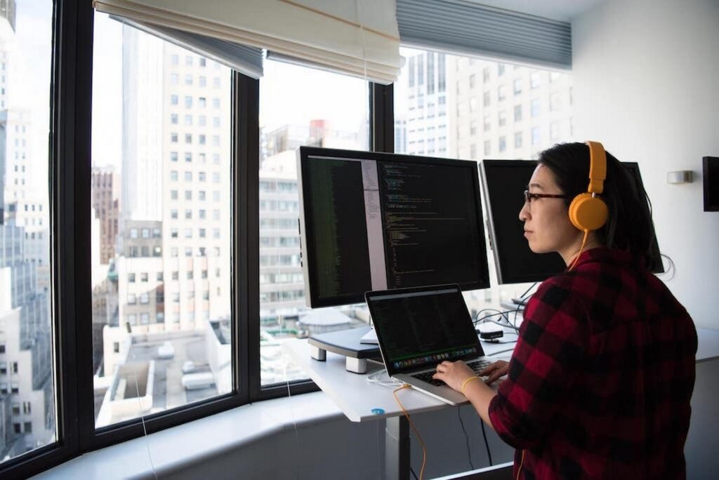 Person working on a laptop while looking at a window