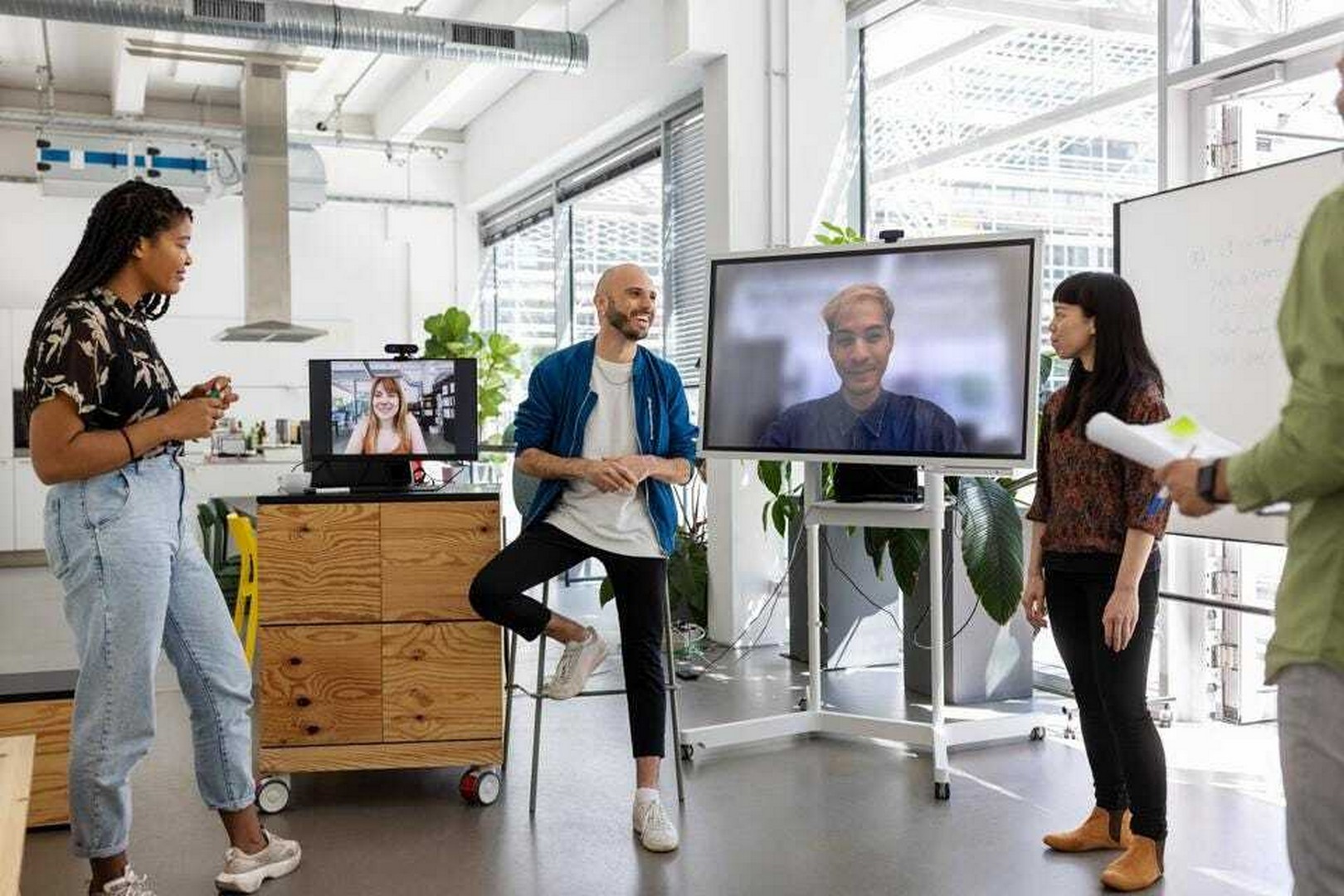 A group of peers on a live call talking and smiling at each other
