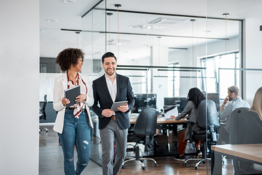 Two coworkers talking and smiling while walking together