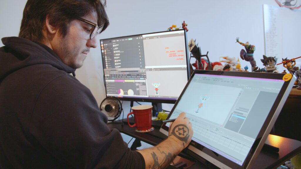 A man drawing an animated character on a monitor