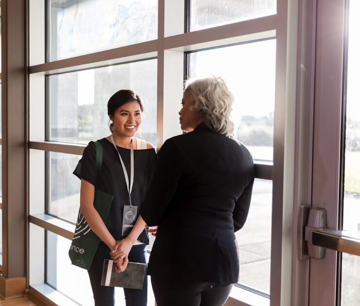 Two coworkers talking and smiling
