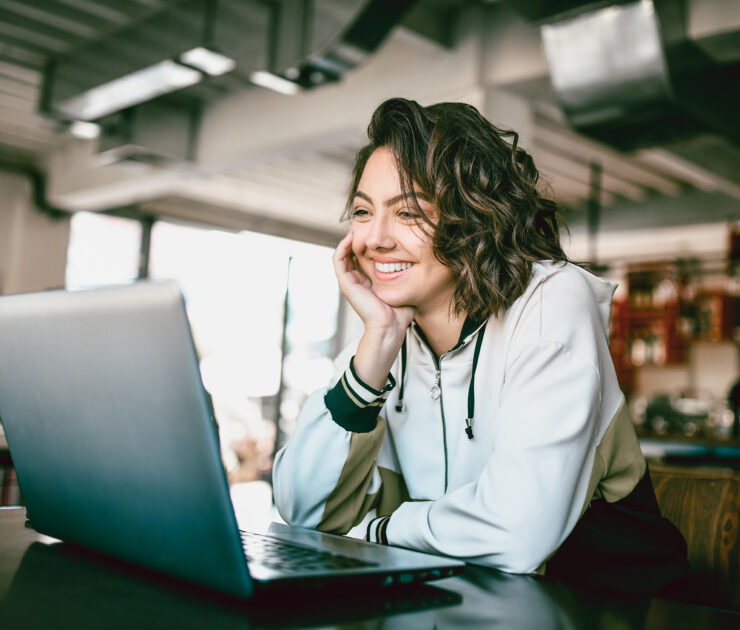Woman smiling while looking at laptop