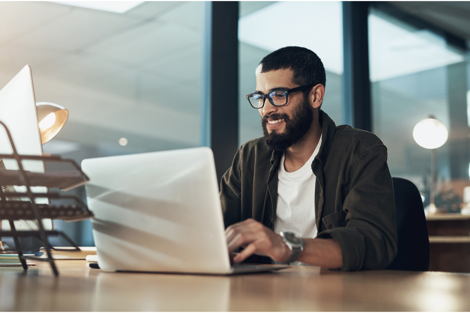 Man typing on laptop and smiling