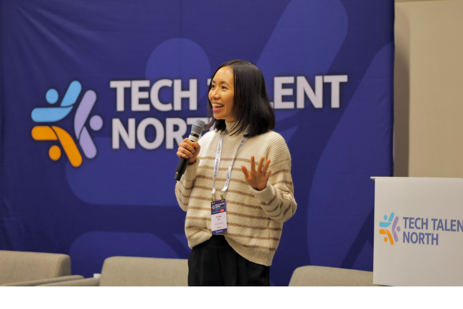 A woman speaking on stage, with a microphone. Tech Talent North