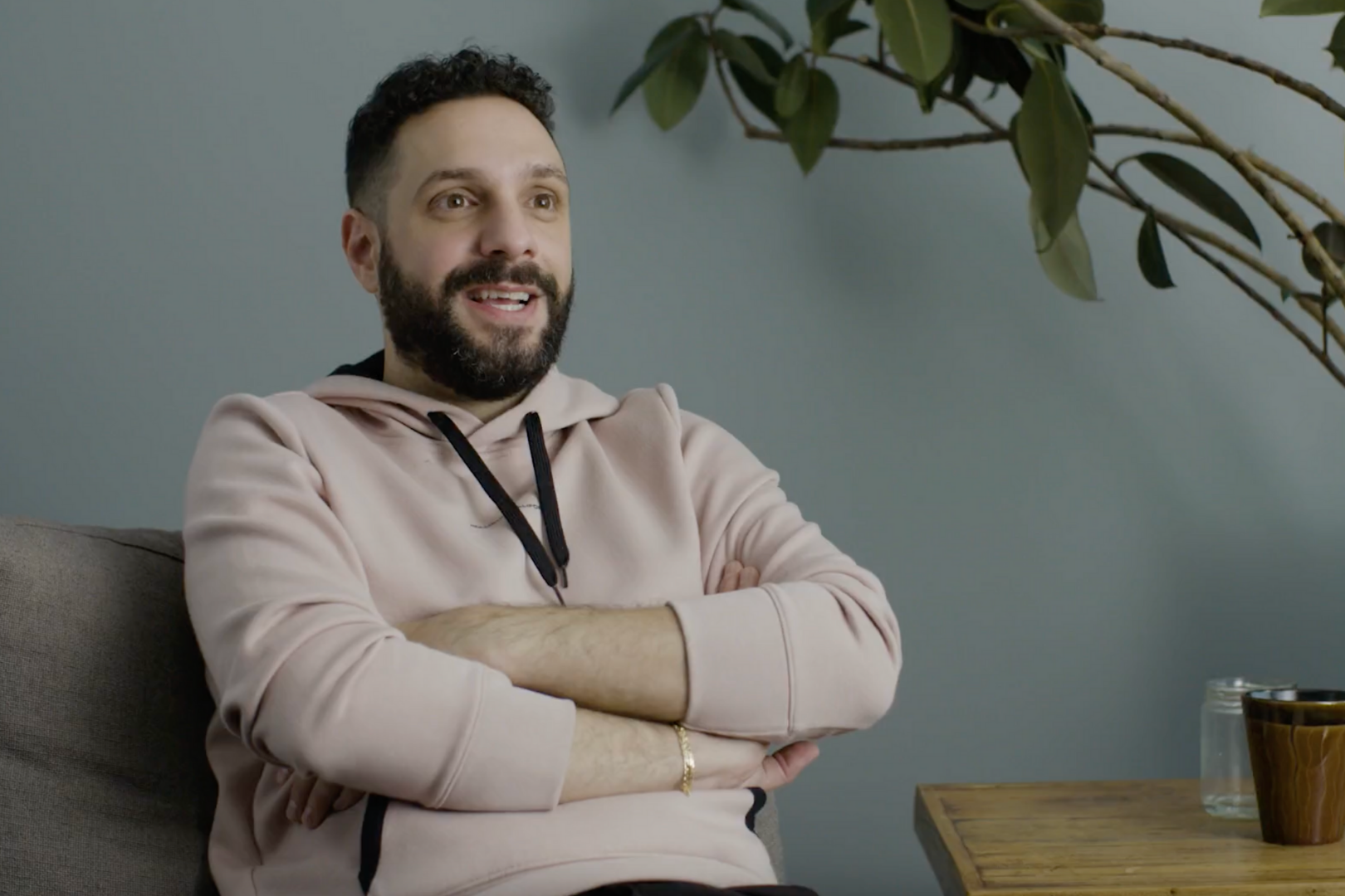 Man sitting with arms crossed, smiling.