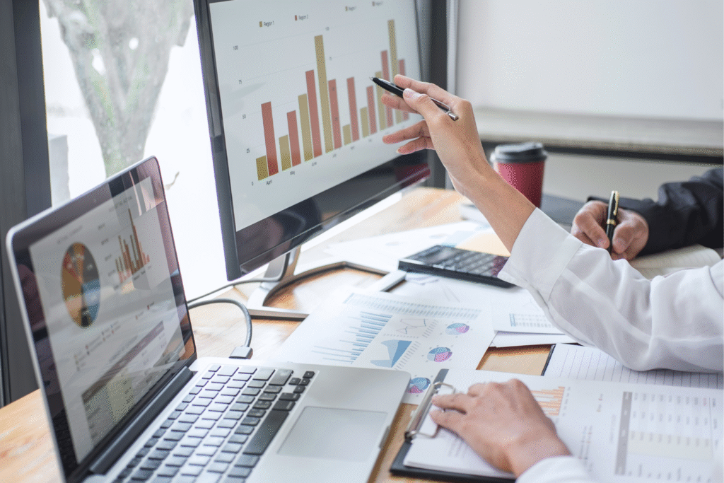 hands pointing at a computer screen, graphics on the screen