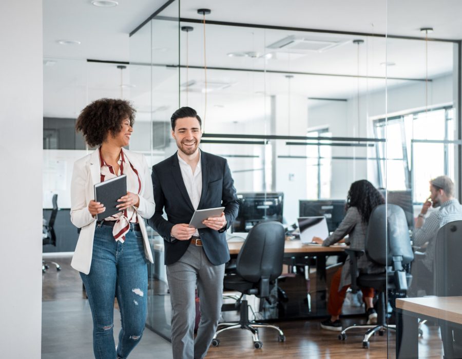 Two coworkers talking and smiling while walking together